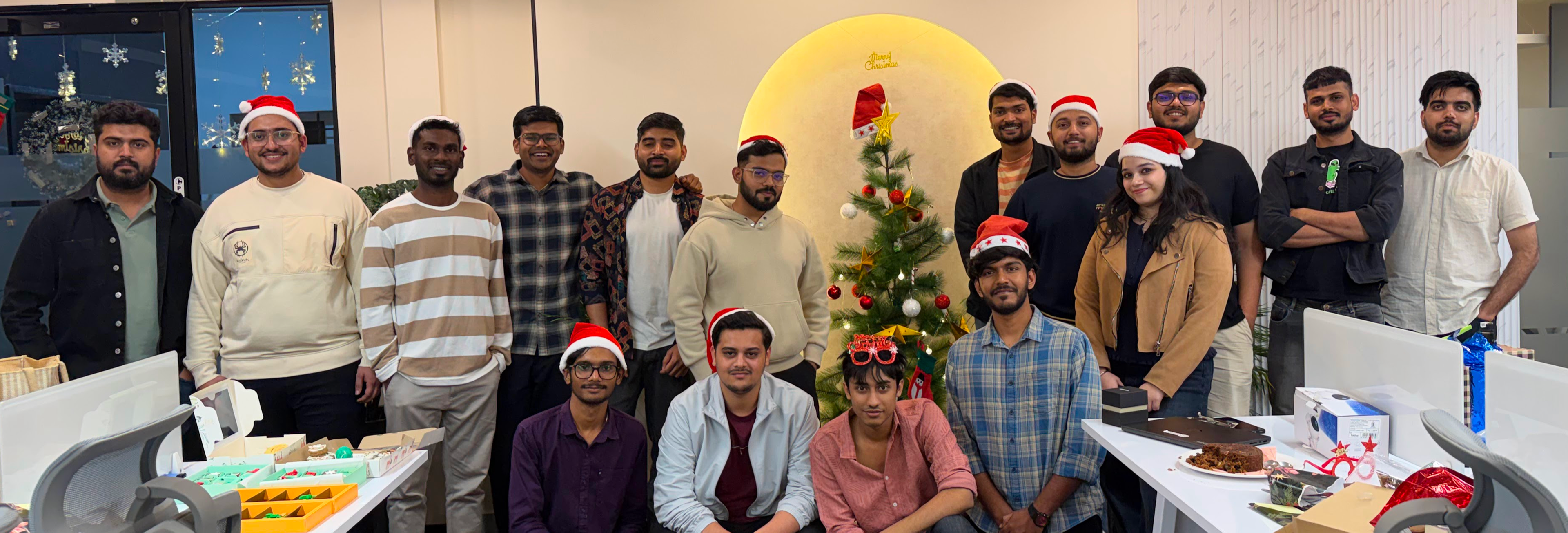 The Outbox Labs team at the office Christmas party, in Santa hats around the tree