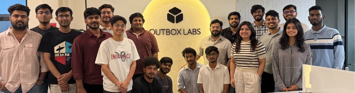 The full Outbox Labs team at the Bangalore office in front of the lit logo wall